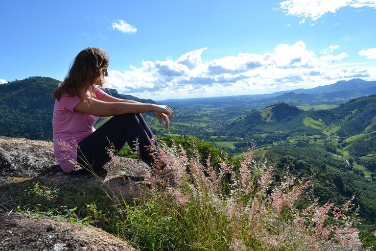 femme sereine sur un sommet regardant l'horizon