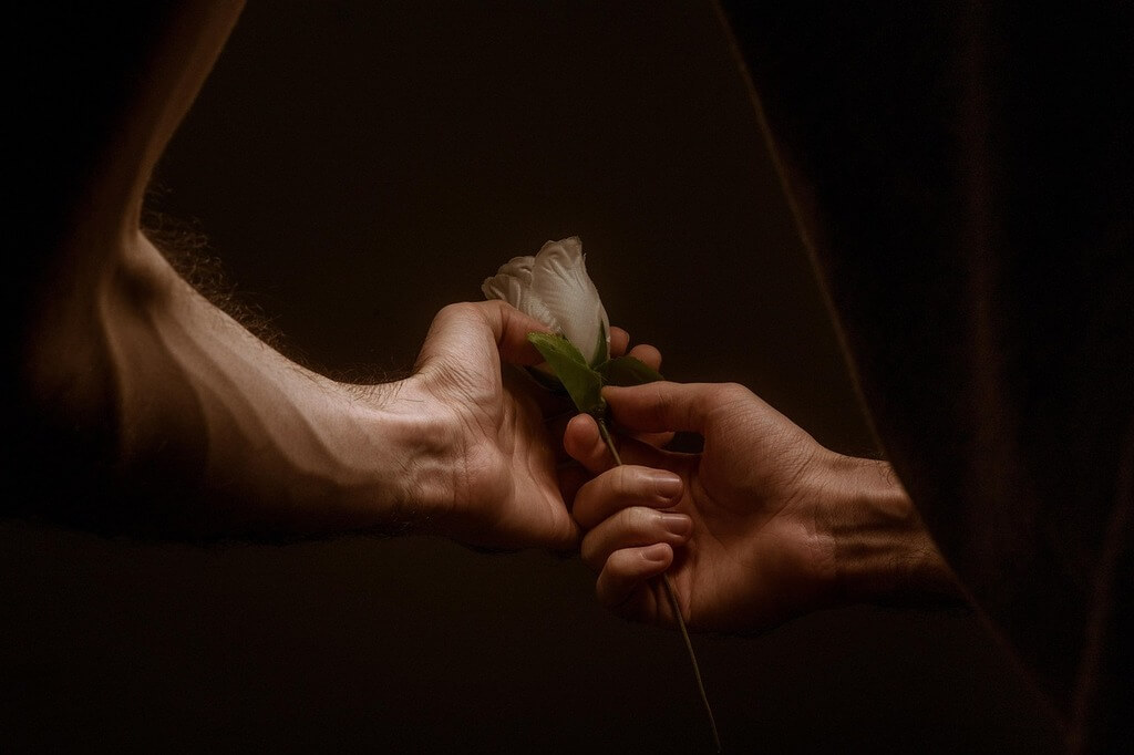 un homme et une femme tenant une rose ensemble
