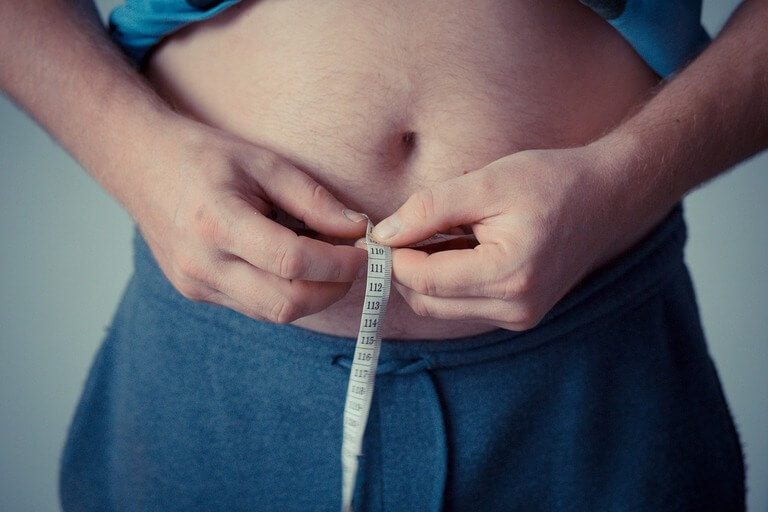 Home mesurant son tour de taille - prise de poids et spondylarthrite ankylosante